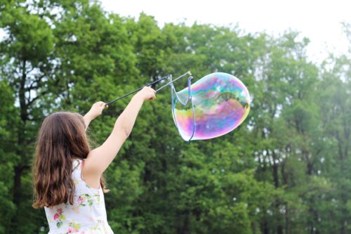 Mäedchen macht Riesen-Seifenblase