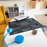 Auf einem Wohnzimmertisch liegt eine beschriftete Kreidetafel mit "Start-Up Service"