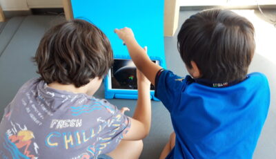 Zwei Buben machen einen Stoptrick-Film mit Tablet, Spielfiguren und Bluescreen