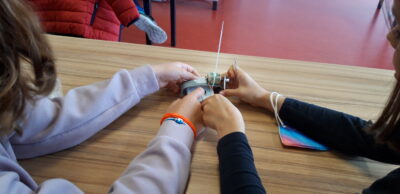 Zwei Kinder bauen den Roboter zusammen.