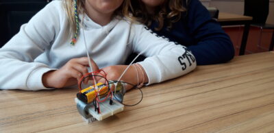 Ein Mädchen präsentiert ihren Roboter.
