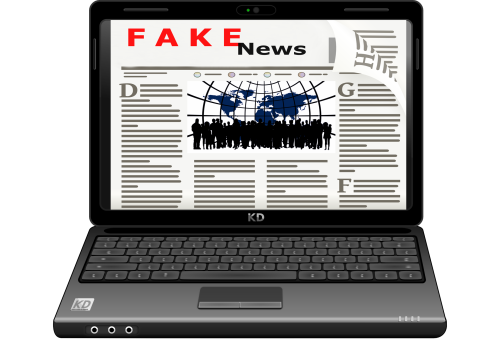 EIn Laptop mit einer Grafik einer Zeitung auf dem Bildschirm und erkennbarer Unterschrift "Fake News".
