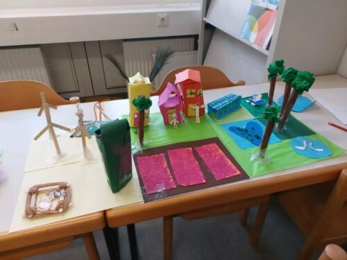 Ein 3D-Modell von einer Stadt mit Häusern, Menschen, Bäumen, Gewässern und Tieren