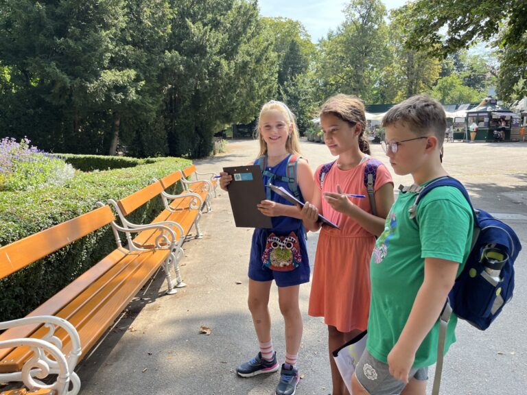 Drei Kinder mit Klemmbrettern im Park