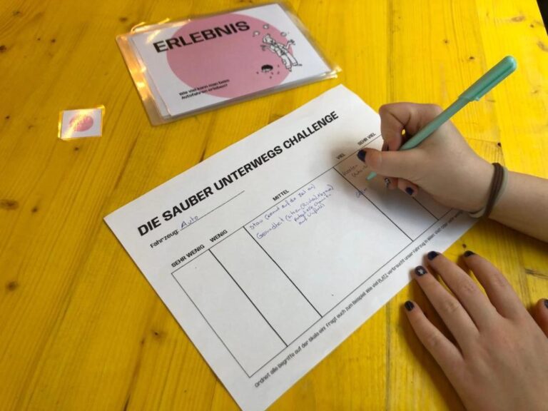 Jemand schreibt mit Bleistift auf einen Zettel.