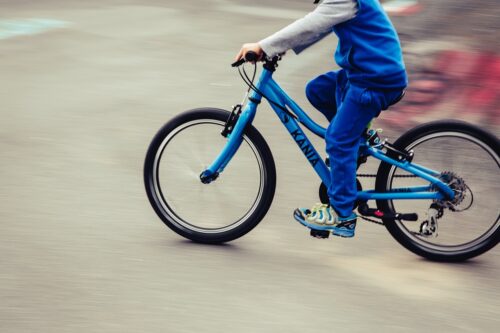 Kind, das auf einem blauen Fahrrad fährt