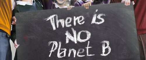 Junge Menschen mit einem Schild, auf dem mit weißer Kreide "There is no Planet B" geschrieben steht