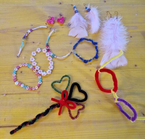 Selbstgebastelter Schmuck aus Perlen und Federn und Pfeifenputzern