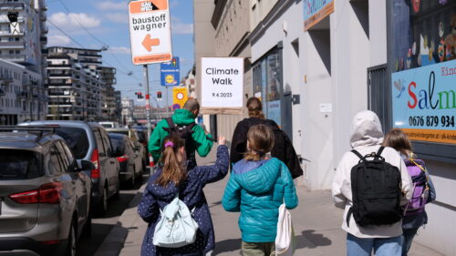 Jugendlichen, die mit Schildern auf dem Climate Walk durch die Straßen von Favoriten gehen