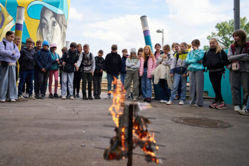 Kinder, die während eines Outdoor-Experiments beobachten, wie etwas kontrolliert abbrennt