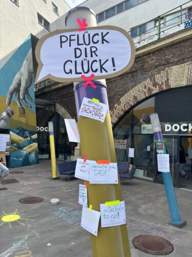 Eine Säule mit Sprüchen zum Mitnehmen und dem Titel "Pflück dir Glück!"