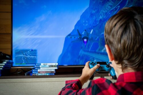 Kind, das mit einer Konsole ein Videospiel spielt