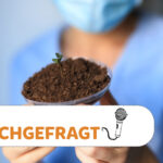 Wissenschafterin, die eine Petrischale mit Erde hält, aus der ein Pflänzchen wächst. Darüber ist der Schriftzug "Nachgefragt"